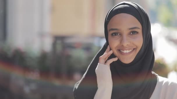 Portrait of young beautiful muslim woman wearing hijab headscarf laughing cheerful in the old city. Close up. - Video