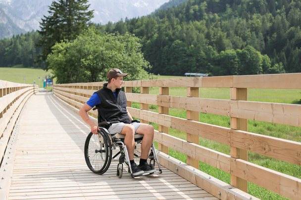 Disabled young man on a wheelchair - Фото, зображення