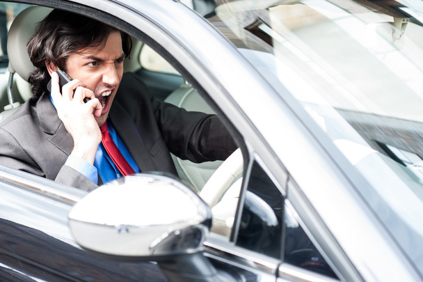 Enojado hombre de negocios gritando mientras conduce
 - Foto, Imagen