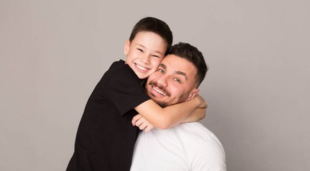 Vidám fiú átölelve az apjával, boldog családi portré - Fotó, kép