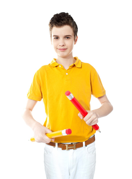 Young kid holding two big colorful pencils - Zdjęcie, obraz