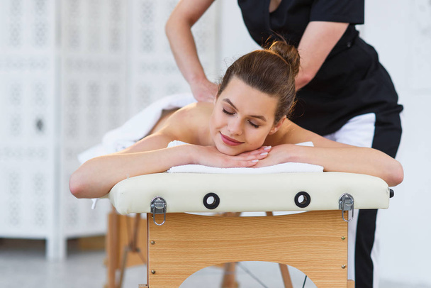 Female masseur making massage in spa salon. - Foto, immagini