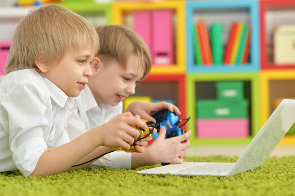 deux garçons jouant à des jeux informatiques sur ordinateur portable
 - Photo, image