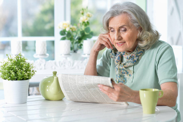 Portrait of senior woman reading newspaper - Foto, afbeelding