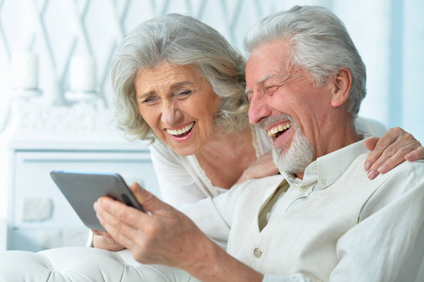 portrait of a happy senior couple using tablet at home - Photo, Image
