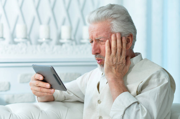 Portrait of  senior man using tablet at home - Foto, Imagem