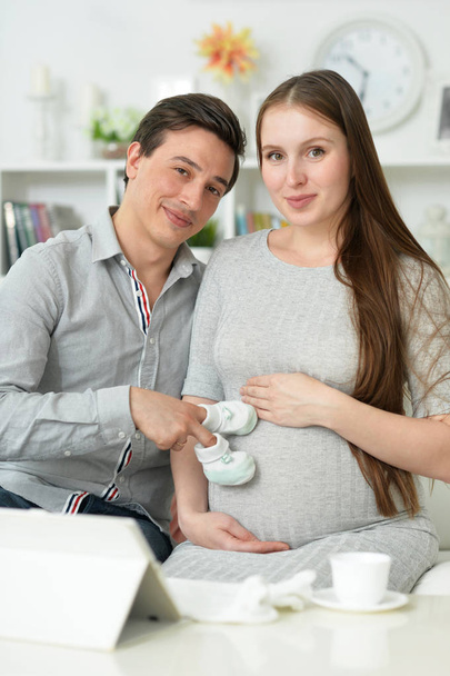 Gelukkig zwangere vrouw met echtgenoot poseren thuis - Foto, afbeelding
