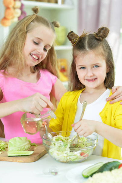 Cute girls preparing delicious fresh salad in kitchen - Φωτογραφία, εικόνα