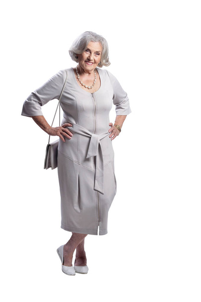Happy senior woman wearing light dress posing isolated on white background - Foto, afbeelding