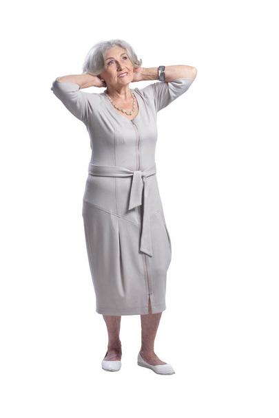 Happy senior woman wearing light dress posing isolated on white background - Photo, image