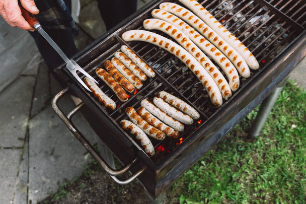 Barbiquing sausages on hot grill. Top view. - Foto, afbeelding