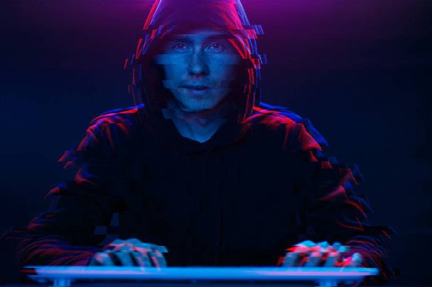 Kapüşonlu hacker karanlık odada bilgisayar yazma metni ile çalışıyor. Glitch efektli görüntü - Fotoğraf, Görsel