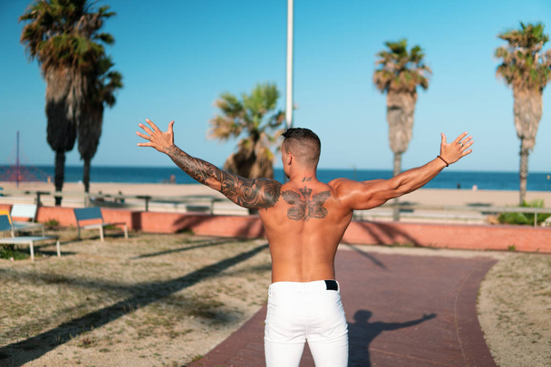 Tattooed bodybuilder sexy male coach at the beach. - Fotografie, Obrázek