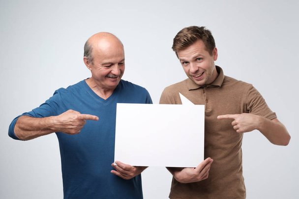due uomini che mostrano copyspace vuoto per l'annuncio
. - Foto, immagini