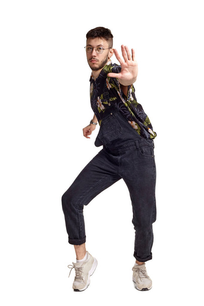 Full-length portrait of a funny guy dancing in studio isolated on white background. - Foto, imagen