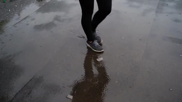 Woman stepping into a pool of water. Girl goes on the sidewalk in a puddle - Filmagem, Vídeo