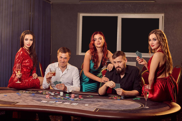 Group of a young rich friends are playing poker in casino. - Photo, Image
