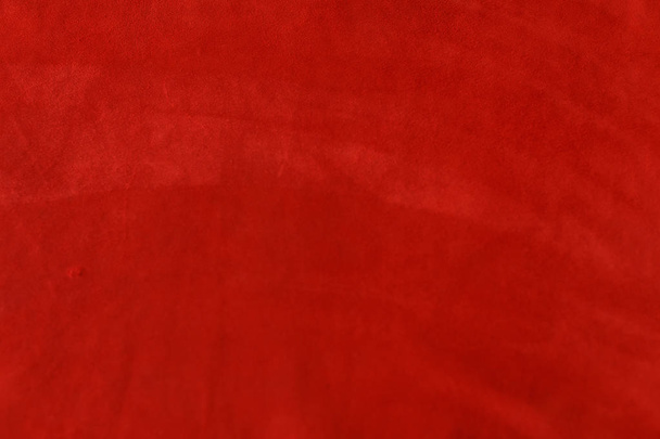 Donker rode matte achtergrond van suède stof, close-up. Fluweel textuur van naadloze wijn leer. - Foto, afbeelding