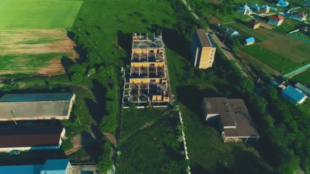 Widok z lotu ptaka budowy budynków mieszkalnych w obszarze wiejskim krótkiego malowniczej przyrody. 4K. - Materiał filmowy, wideo