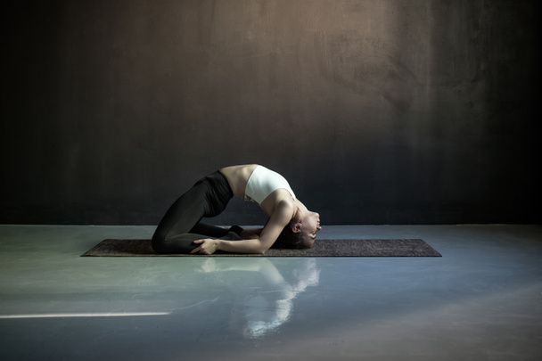 Kobieta ćwiczy jogę, ćwiczy gołębie, pozuje na Kapotasanę.. - Zdjęcie, obraz