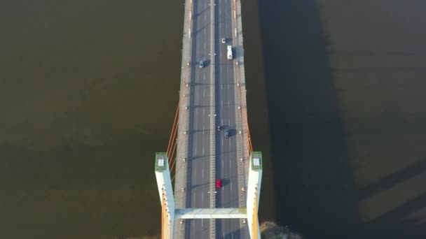 Widok z lotu ptaka ruchu samochodowego na nowoczesny most nad rzeką w mieście w letni dzień - Materiał filmowy, wideo
