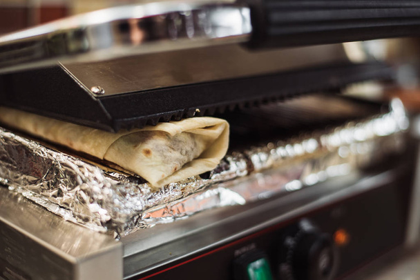 Shawarma Döner sütött egy villanysütőben egy gyorsétteremben. - Fotó, kép