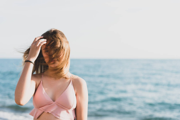 young slim beautiful woman in pink bikini on tropical beach.  - Фото, изображение