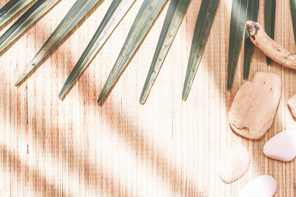 tropische Palmblätter auf einer Strohmatte mit Muscheln. flache Lage,  - Foto, Bild
