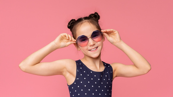 Menina bonito em óculos de sol elegantes desfrutando de tempo de verão
 - Foto, Imagem