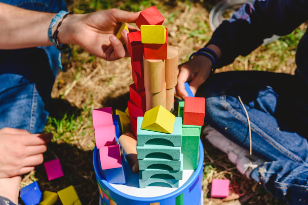 Manos de niños jugando con bloques de colores en un día soleado de verano
 - Foto, imagen