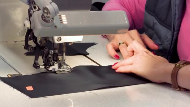 Una costurera cose telas en la línea de producción atelier tela. Primer plano de una máquina de coser
. - Metraje, vídeo