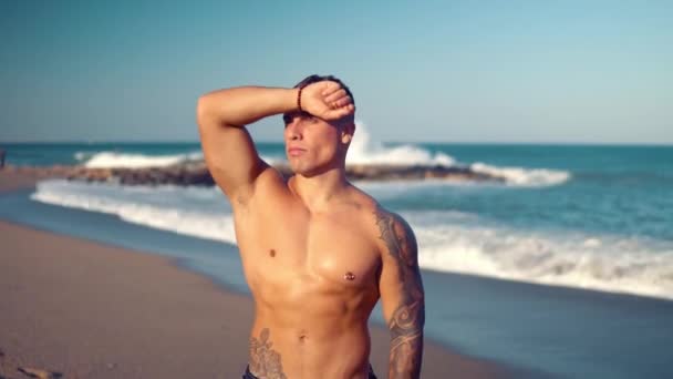 Tattooed bodybuilder sexy male coach at the beach. - Footage, Video