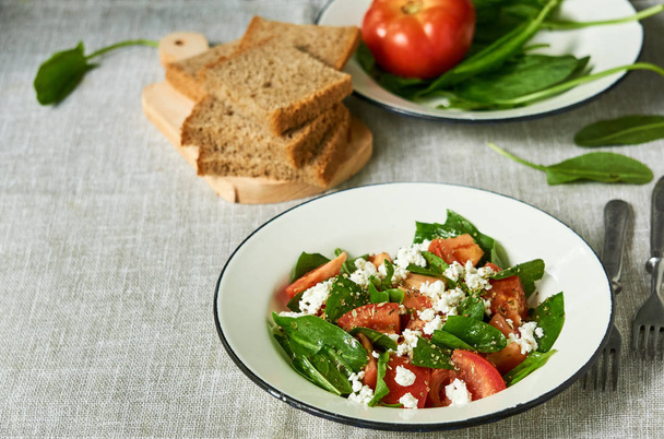 Tomato salad with sorrel and cottage cheese in a white bowl                                - Photo, Image