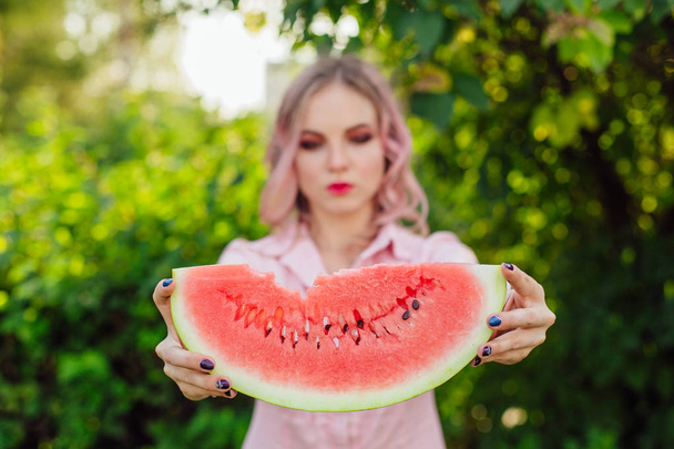 Beautiful young woman with pink hair holding watermelon - Foto, Imagen