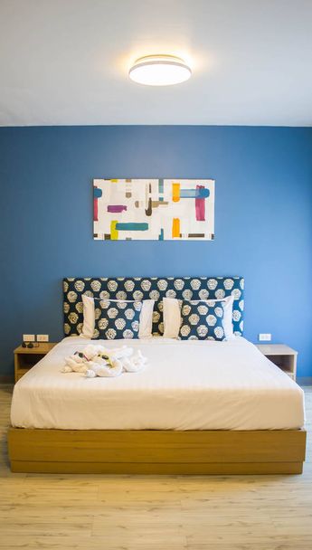 quarto com parede azul e piso de madeira
 - Foto, Imagem