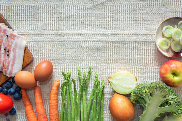 Zdravá výživa rostlinná jídla s konceptem pro kopírování prostoru, Nejlepší pohled na suroviny s cibulí, chřestem, brokolicí, rajčaty, mrkví, Hřebenlkem, paprikou, slaninou, vejci a Mixovými plody na stole. - Fotografie, Obrázek