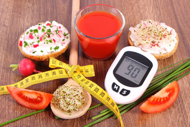Medidor de glicose, sanduíche fresco, sumo de tomate e centímetro. Diabetes e nutrição saudável
 - Foto, Imagem