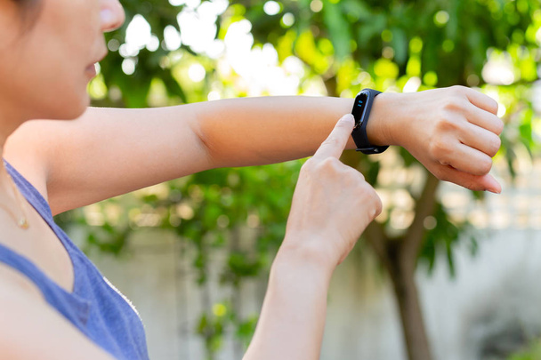 Gezondheidszorg concept vrouw controleren fitness armband monitor op slimme horloge. - Foto, afbeelding