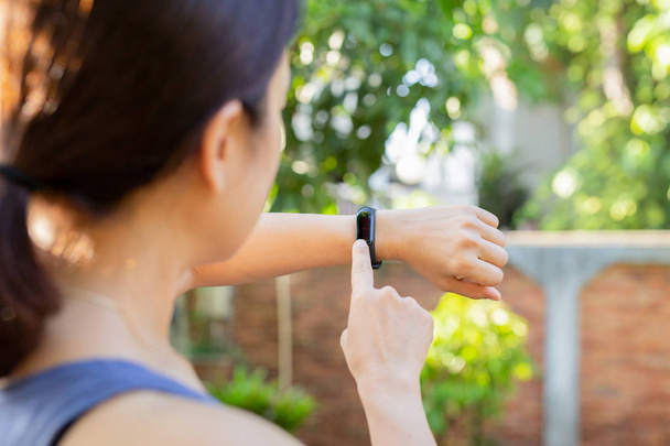 Gesundheitskonzept Frau überprüft Fitnessarmbandmonitor auf Smartwatch. - Foto, Bild