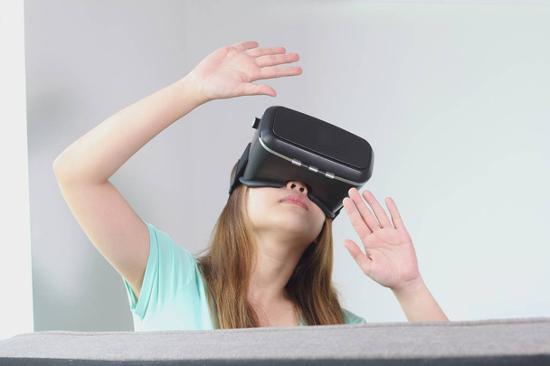 Mujer joven con gafas de realidad virtual en casa
. - Foto, Imagen