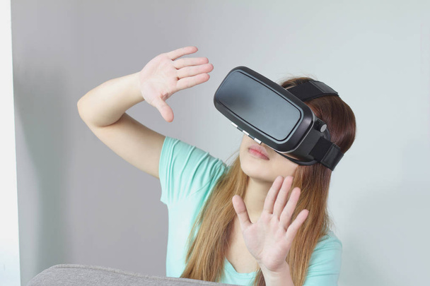 Młoda kobieta w domu sobie okulary wirtualnej rzeczywistości. - Zdjęcie, obraz