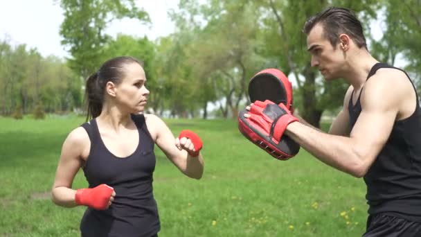 4. Process of boxer training  man and woman witn  boxing paws. City park outdoor . Steady  shot,  - Footage, Video