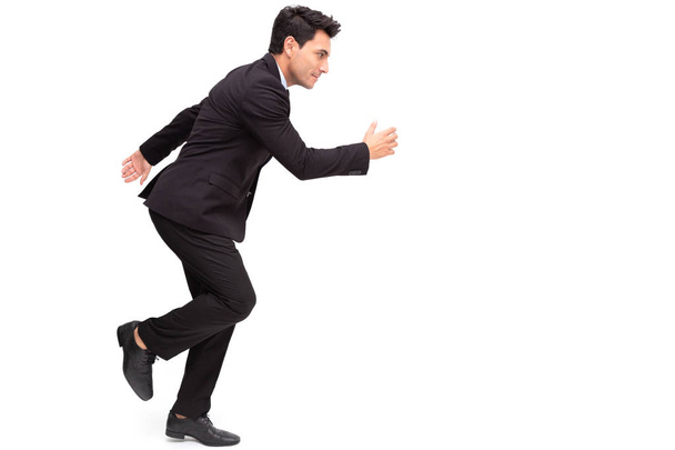 Handsome Caucasian businessman in formal suit is running isolated over white background - Photo, image