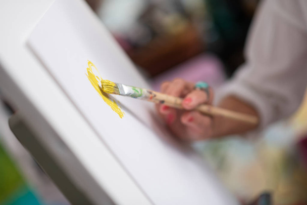 Close up of painting brush with bright yellow gouache - Фото, зображення