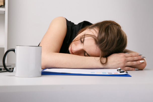 Mujer cansada y soñolienta en el trabajo por la mañana. Taza de café en la oficina
. - Foto, imagen