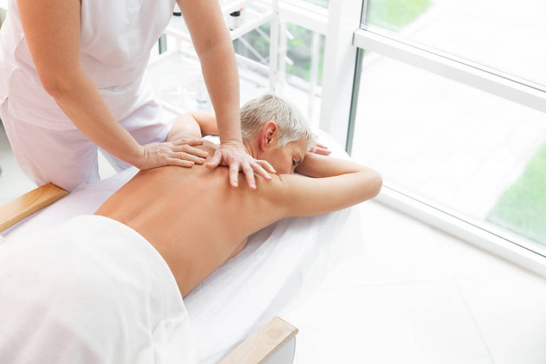 Nice mature woman having a back massage - Φωτογραφία, εικόνα