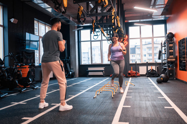 Overweight woman having obstacle race in gym with her trainer - Fotoğraf, Görsel