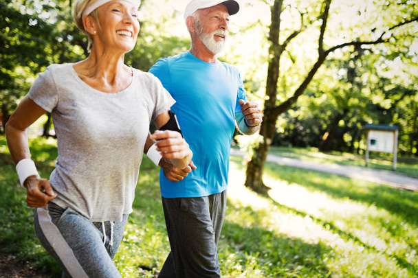 Senior couple jogging and running outdoors in nature - Zdjęcie, obraz
