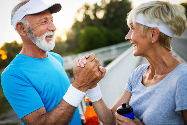 Happy senior couple staying fit by exercise jogging - Foto, Imagem