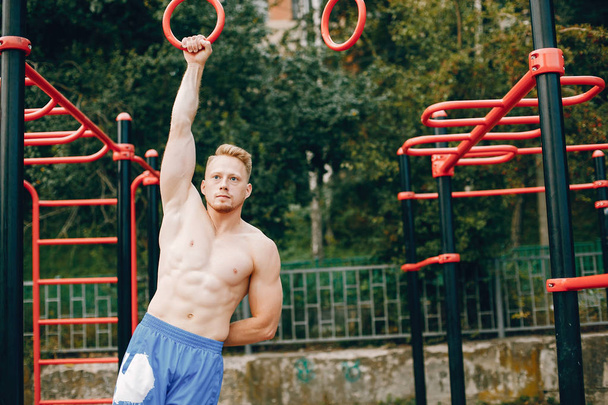Handsome man training in a summer park - Foto, immagini